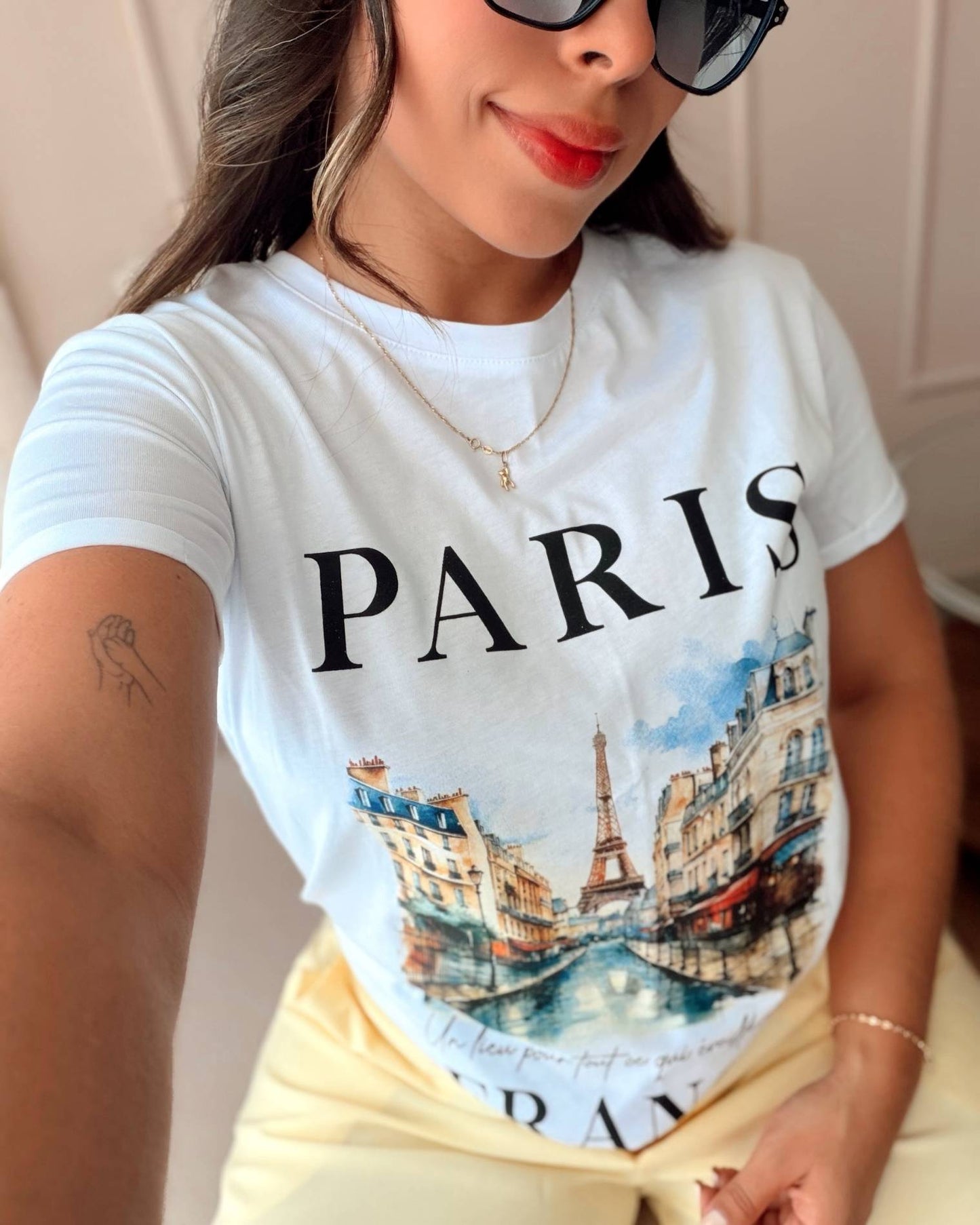 Detalle del estampado artístico de Paris en camiseta blanca de mujer, textura suave en 100% algodón Pima premium