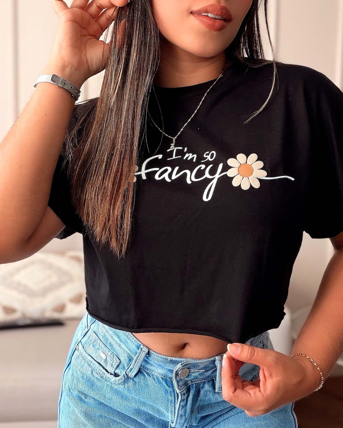 Modelo vistiendo la camiseta crop negra I'm So Fancy, destacando el estampado floral y el ajuste moderno a la cintura, ideal para un look casual y sofisticado de Mozzaar.