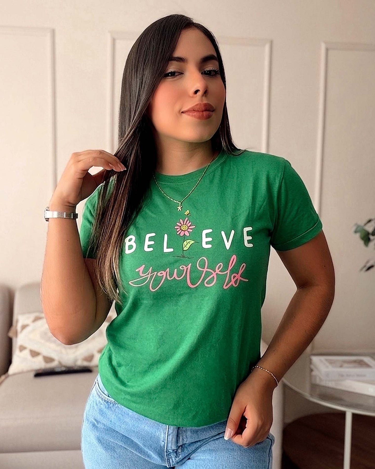 Modelo luciendo camiseta verde esmeralda con frase Believe in yourself y diseño de flor, confeccionada en 100% algodón Pima, marca Mozzaar.