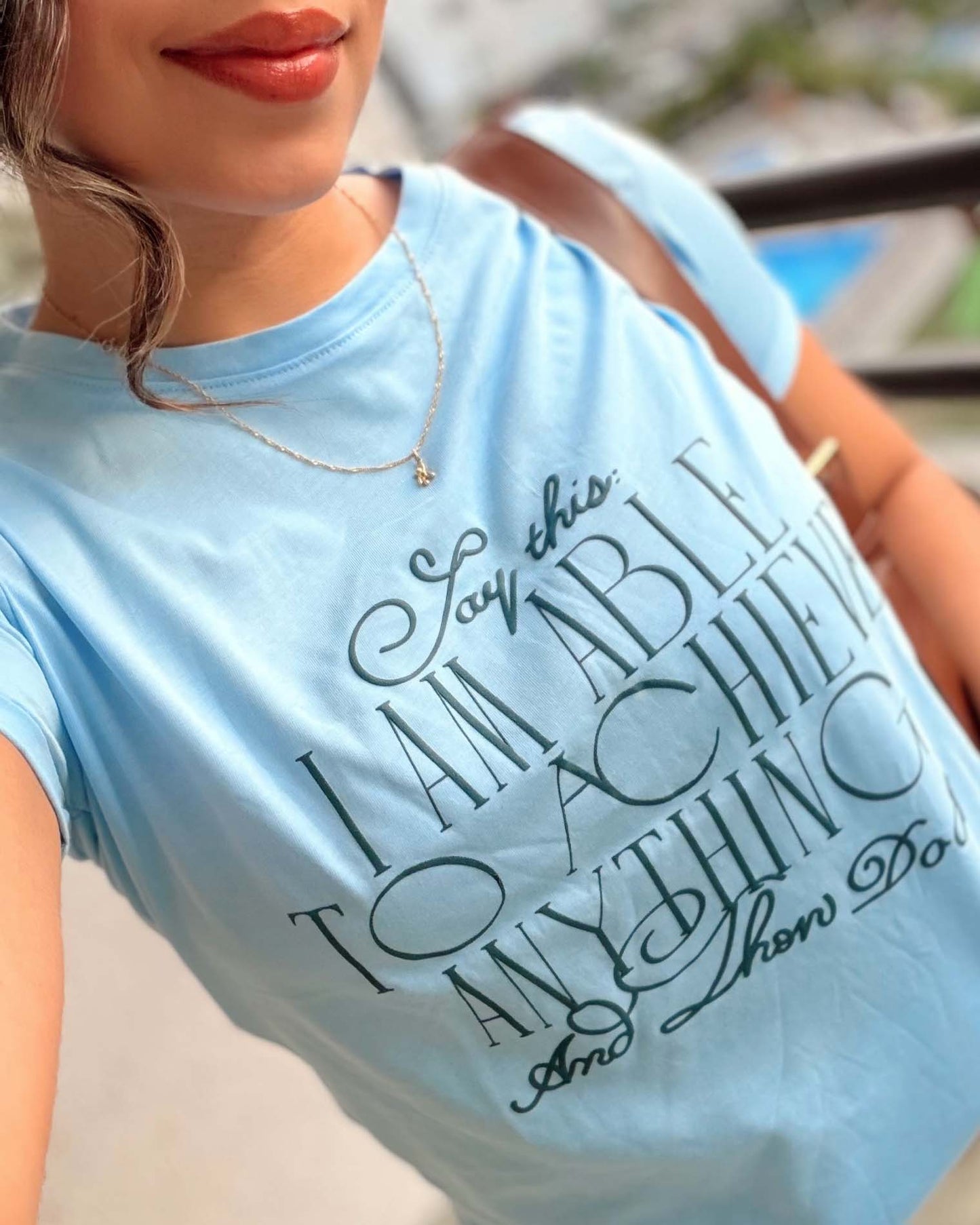 Detalle del estampado en negro sobre camiseta azul cielo para mujer, calidad premium Mozzaar.