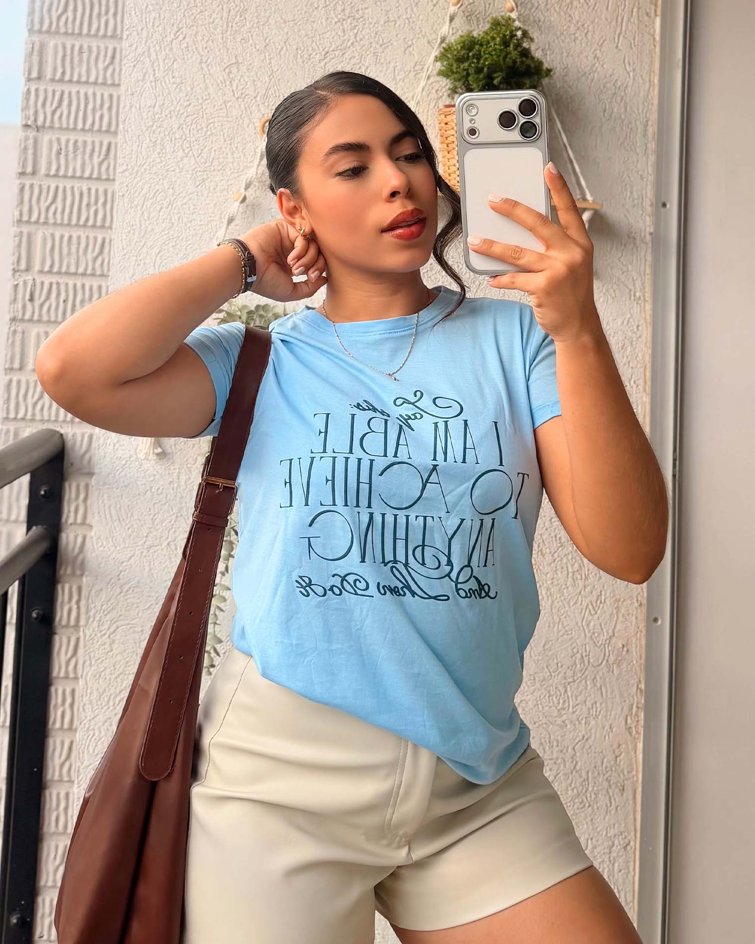 Modelo luciendo camiseta azul pastel con diseño tipográfico inspirador, calidad premium en algodón suave de Mozzaar.