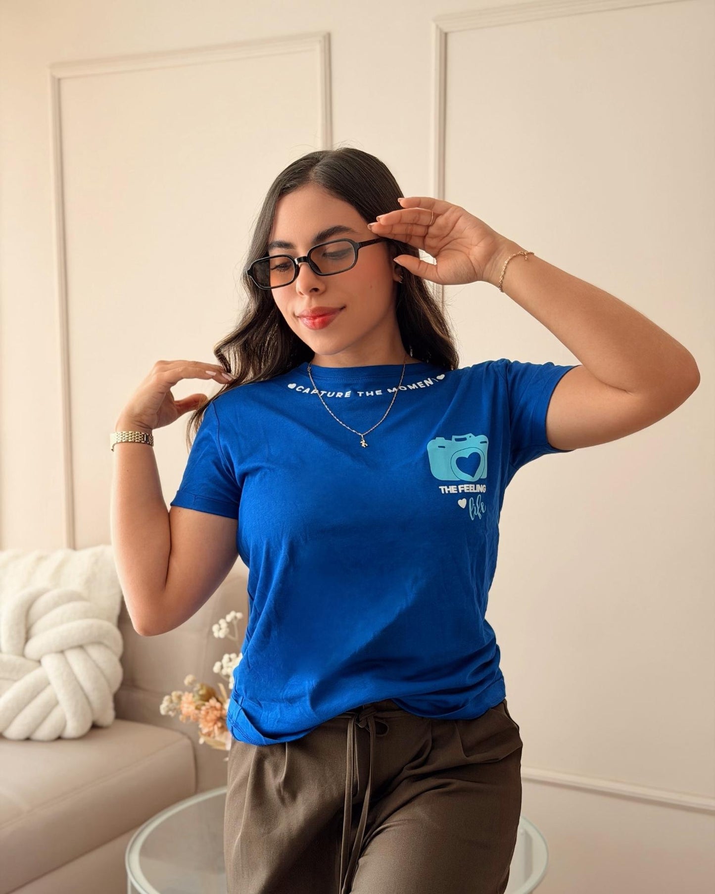 Modelo luciendo camiseta azul rey de mujer con diseño de cámara, estilo casual urbano para el día a día, calidad premium en algodón suave de la marca Mozzaar.