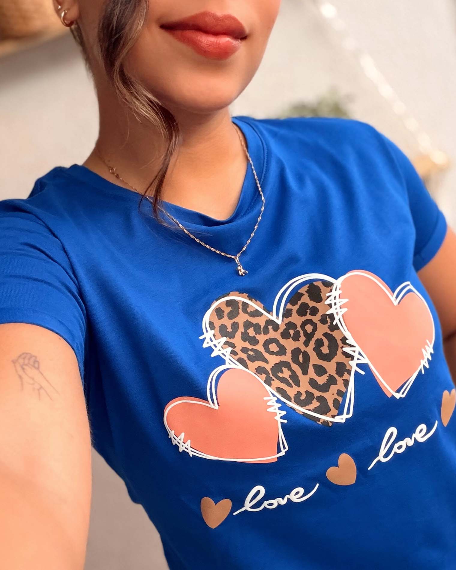 Detalle del estampado de corazones y animal print sobre camiseta azul de algodón premium Mozzaar.