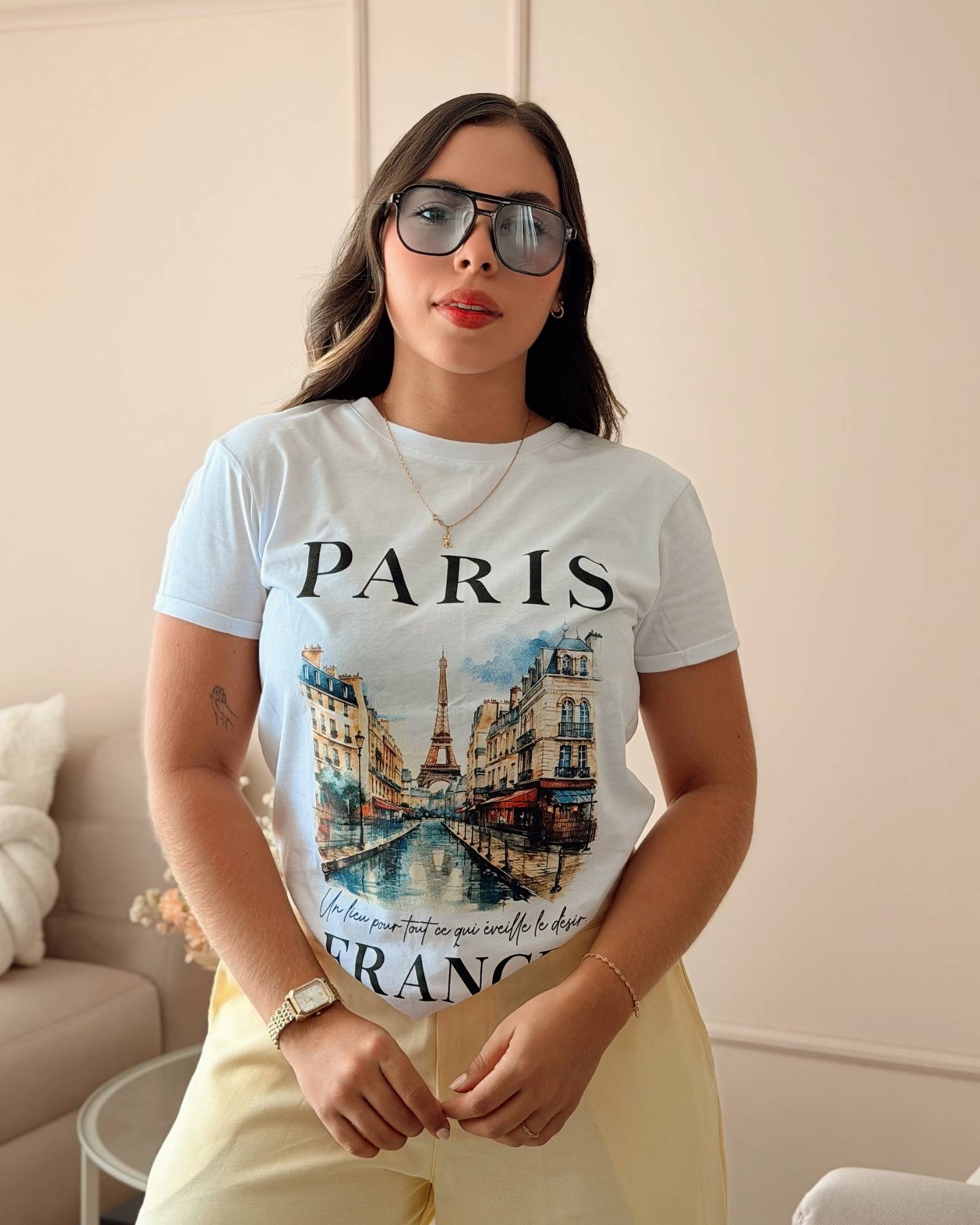 Modelo luciendo camiseta blanca de mujer con diseño urbano de Paris, estilo casual chic, calidad premium de la marca Mozzaar.