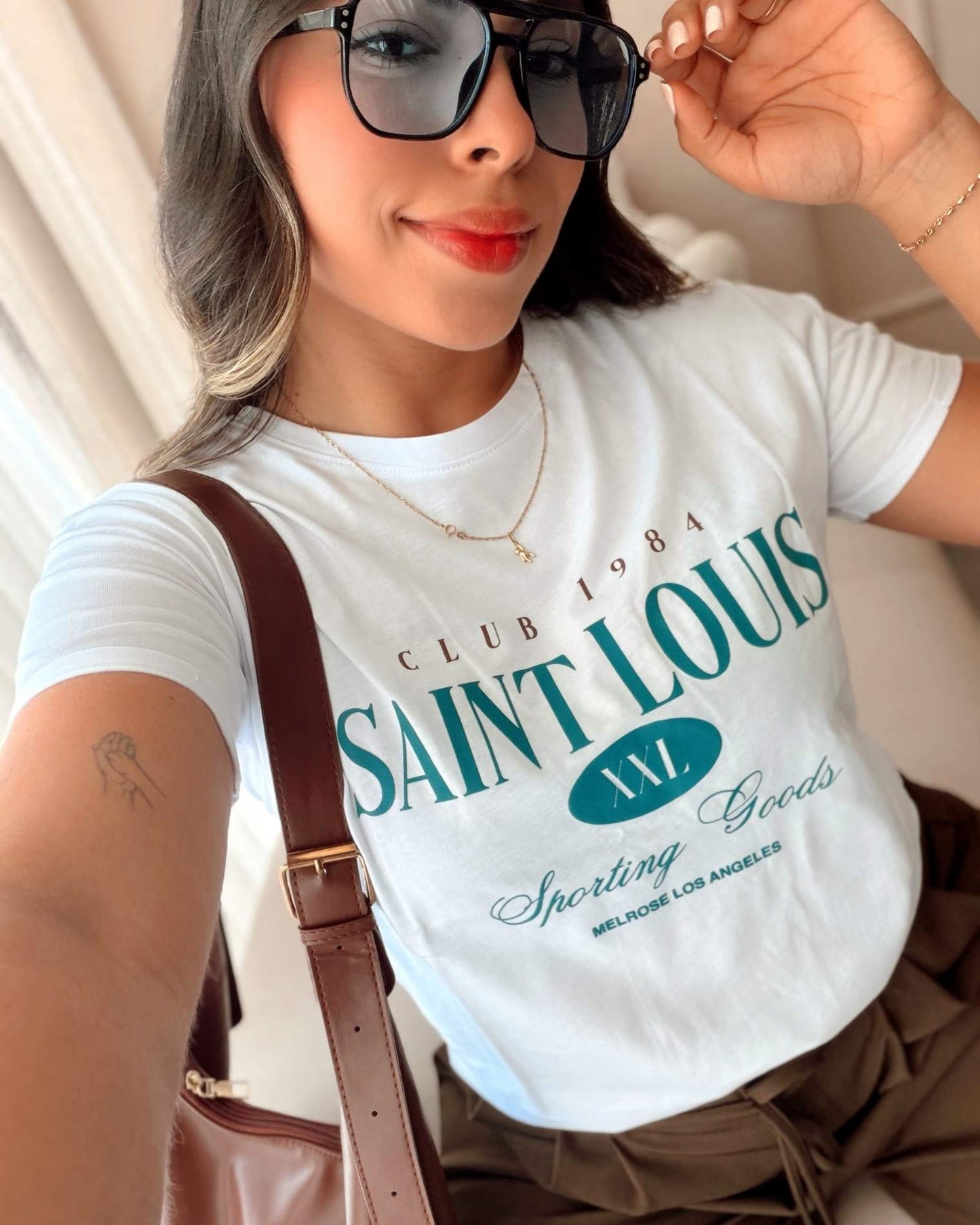 Camiseta blanca para mujer con estampado tipográfico "Saint Louis", silueta regular fit, marca Mozzaar, confeccionada en 100% algodón Pima premium.