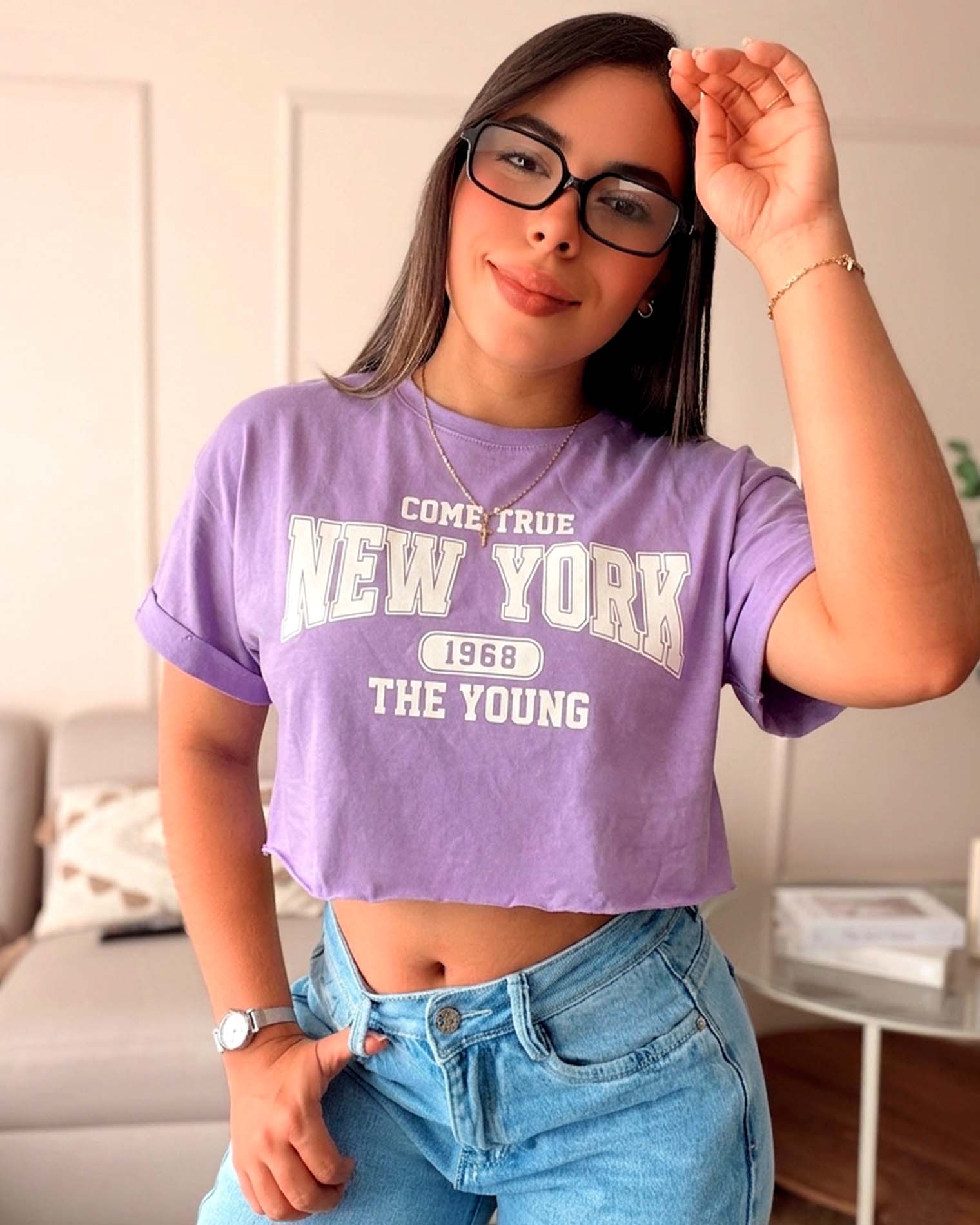 Modelo luciendo camiseta morada de silueta corta con estampado de New York 1968, calidad premium en algodón Pima de la marca Mozzaar.