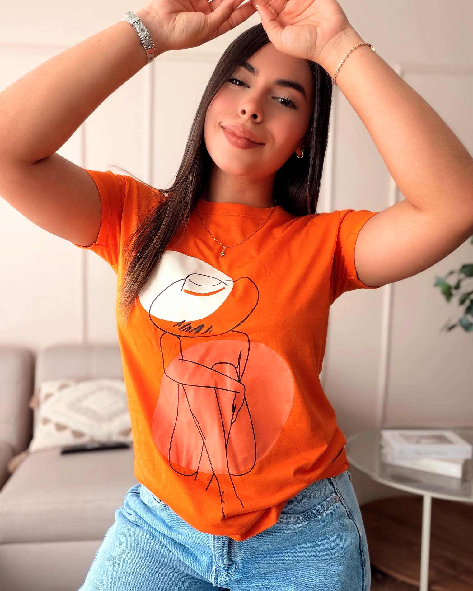Camiseta naranja para mujer con ilustración lineal de mujer con sombrero, marca Mozzaar, confeccionada en 100% algodón Pima.