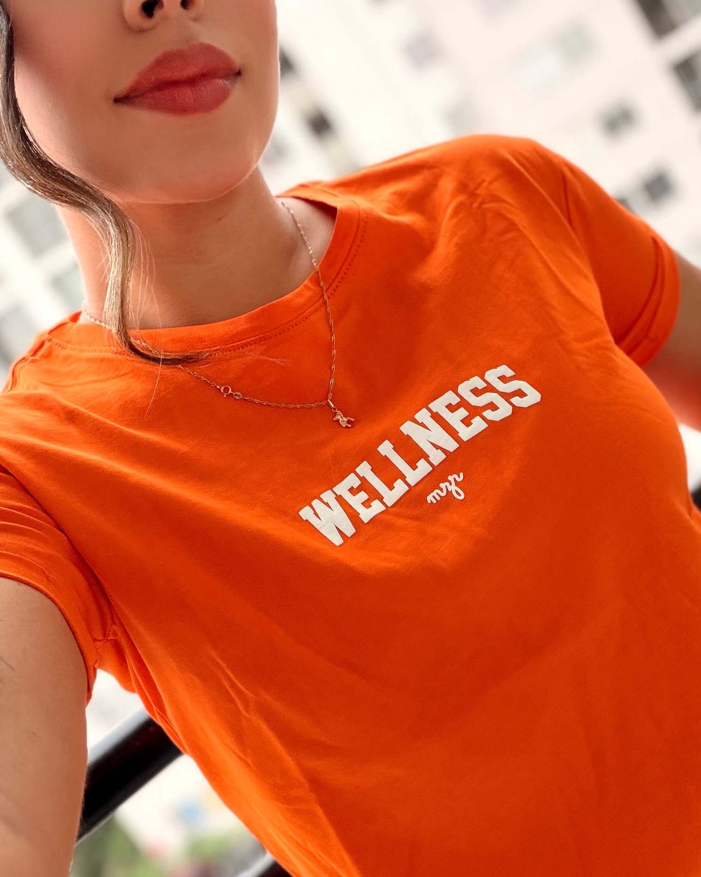 Modelo luciendo camiseta naranja de estilo deportivo y minimalista, calidad premium en algodón suave de la marca Mozzaar.