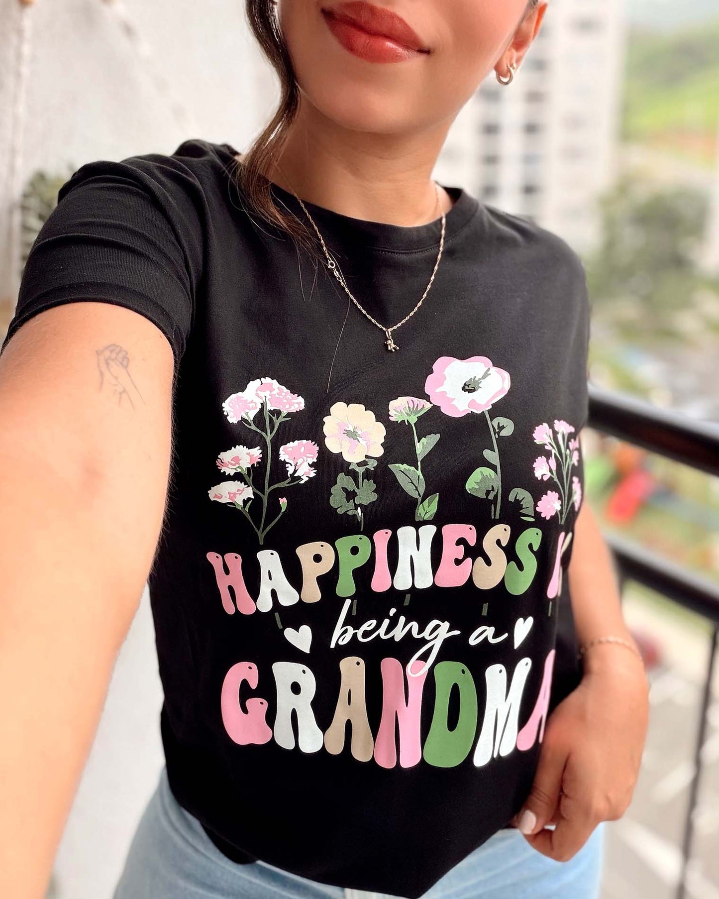 Camiseta negra para mujer con flores y frase Happiness is being a Grandma, marca Mozzaar, 100% algodón Pima.