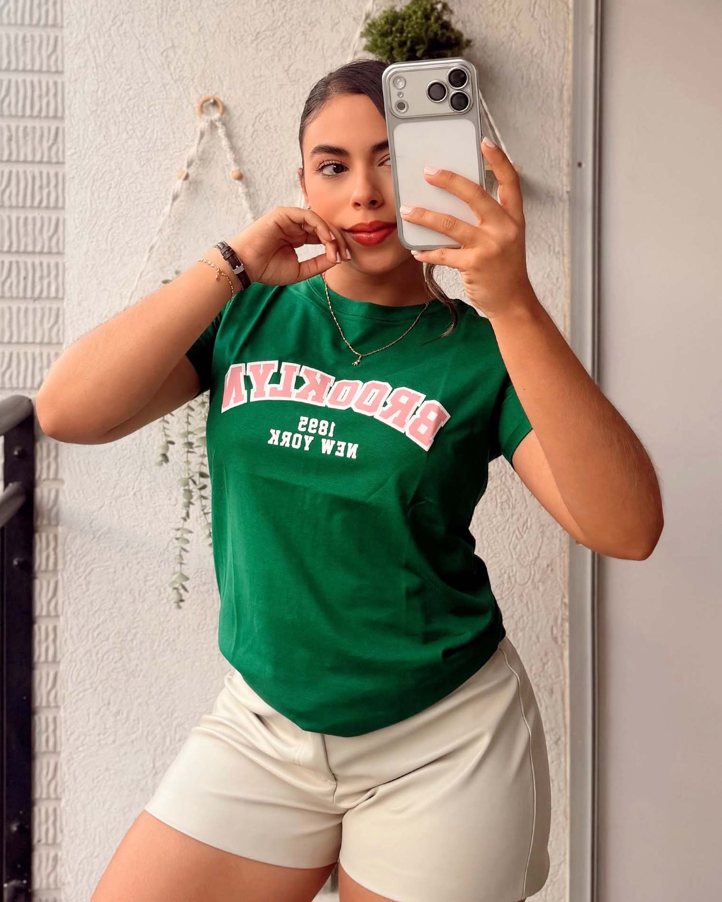 Modelo luciendo camiseta verde de estilo universitario, calidad premium en algodón suave de la marca Mozzaar.